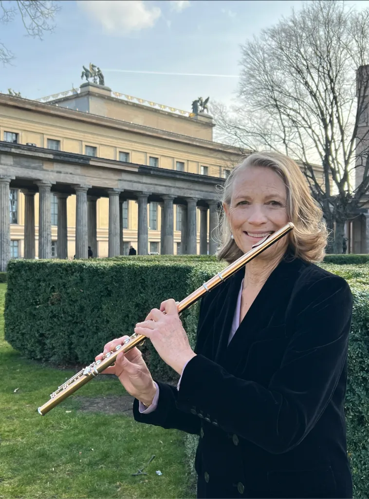 Barbara Hill playing the flute in front of a colonnade in Berlin