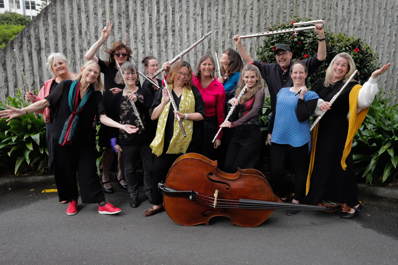 Vivo Flutes posing outdoors with their flutes, a double bass at their feet